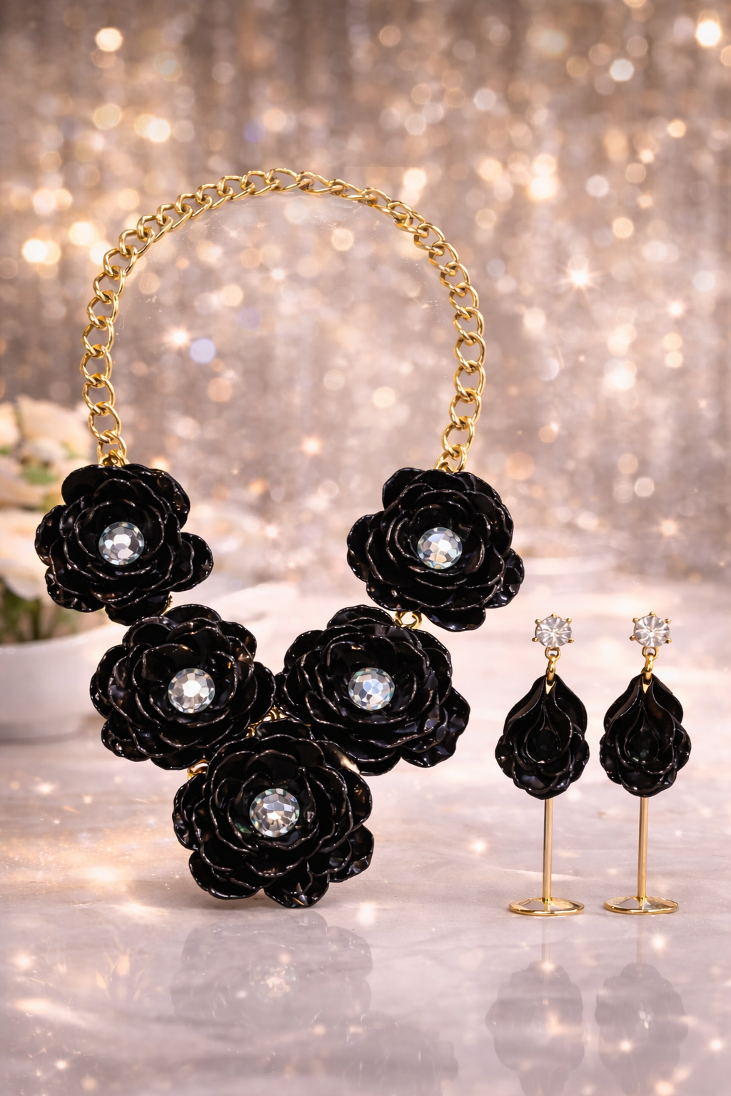 Black rose flower jewelry set featuring a bold gold tone necklace and matching drop earrings.
