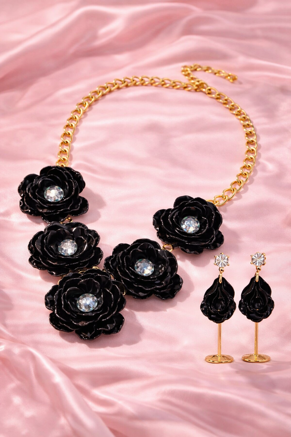 Black rose flower jewelry set featuring a bold gold tone necklace and matching drop earrings.